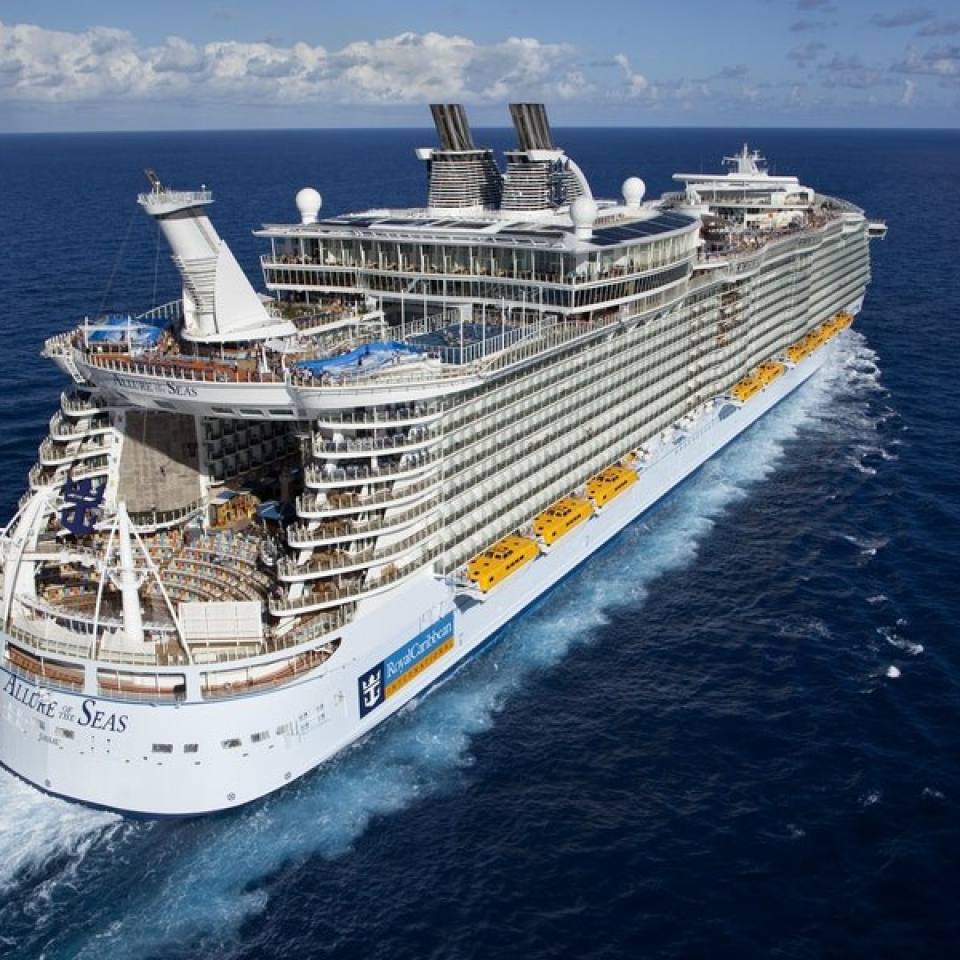 Aerial photo from the back of the cruise ship Allure of the Seas sailing on dark blue waters on a sunny day