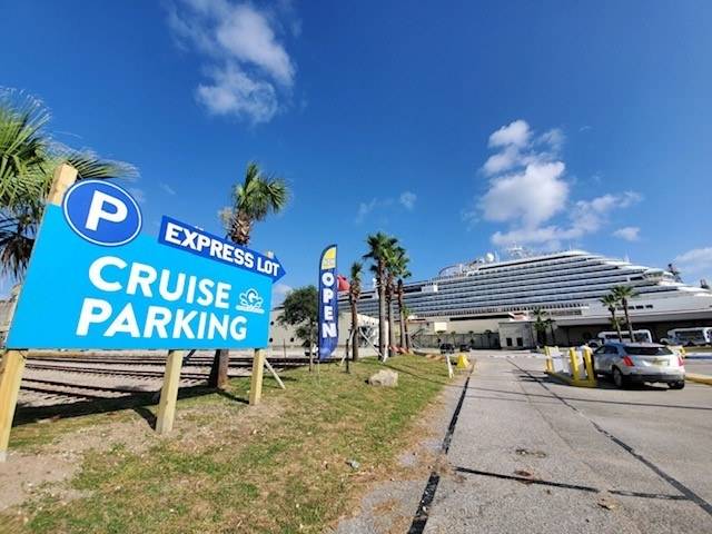 sign for the Cruise line parking lot reading "Cruise Parking Express Lot" with a cruise ship in the distance