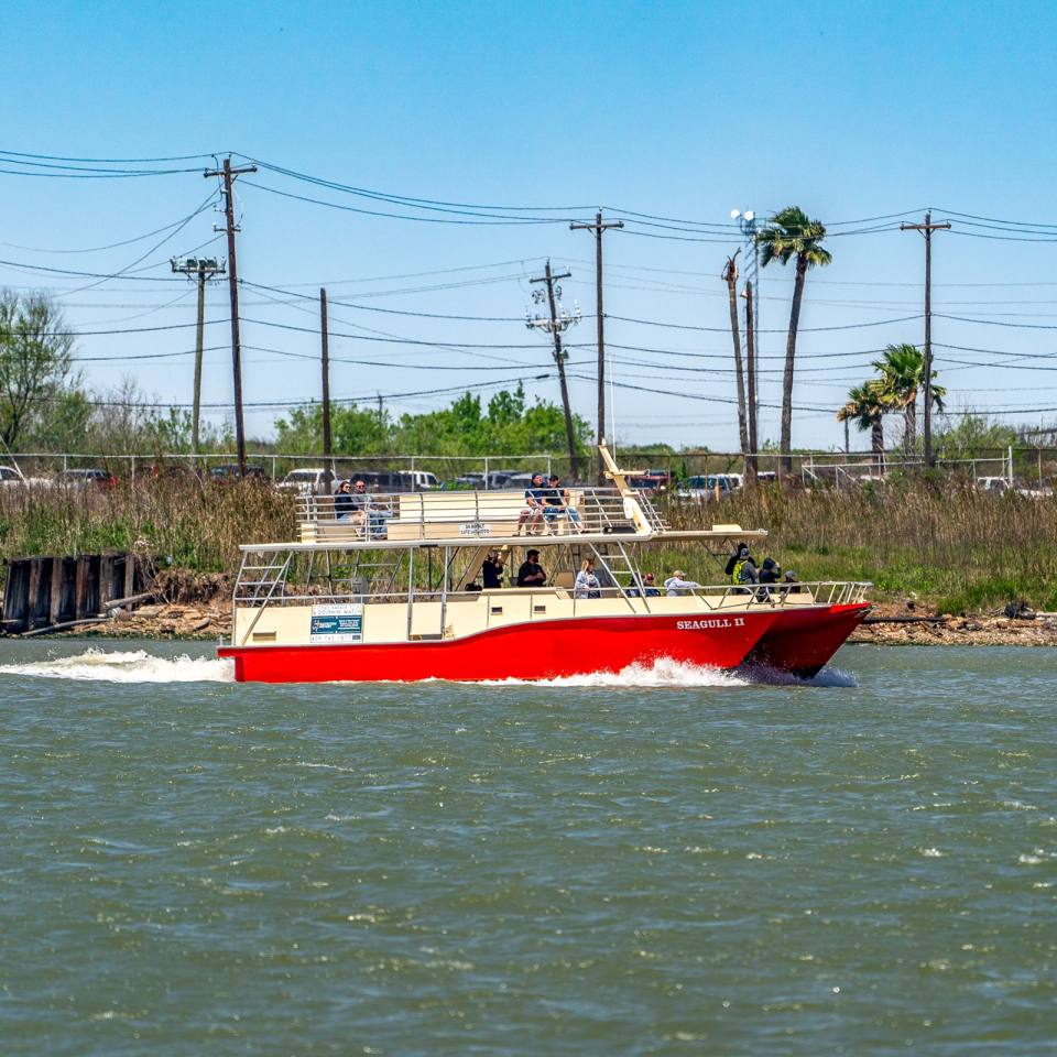 Harbor tour boat riding through water in Galveston TX