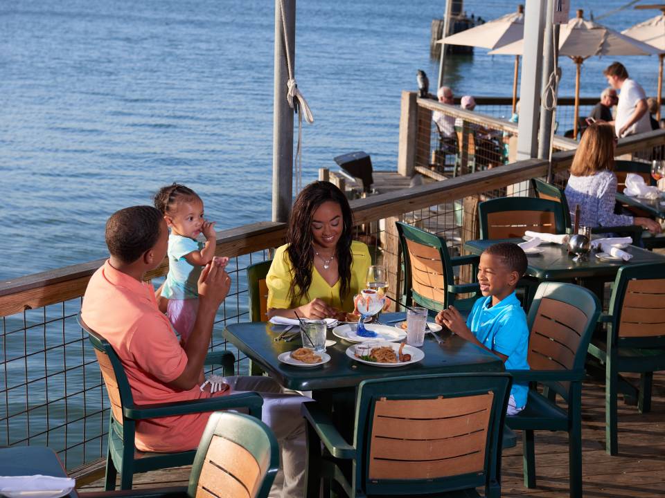 Family dining outdoors on waterfront at Fisherman's Wharf in Galveston TX