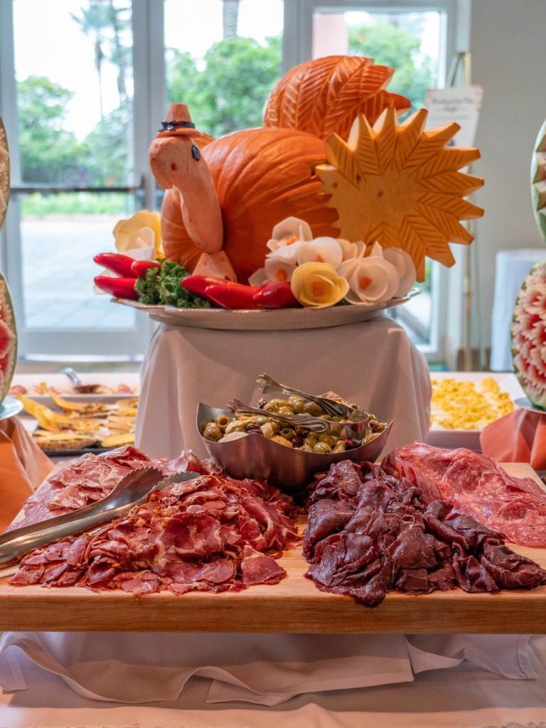 Centerpiece of a turkey made out of a pumpkin surrounded by charcuterie for Thanksgiving at Moody Gardens