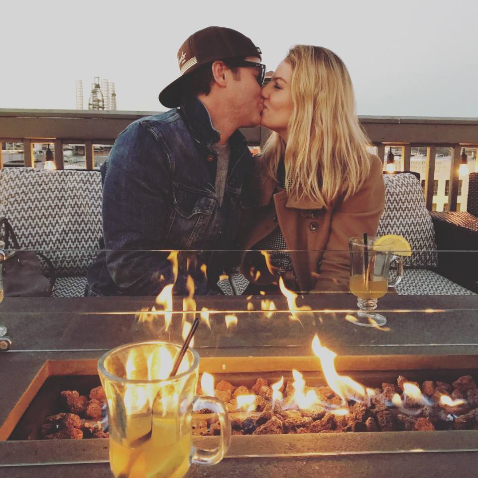 a couple kissing while enjoying cocktails at a rooftop bar in Galveston