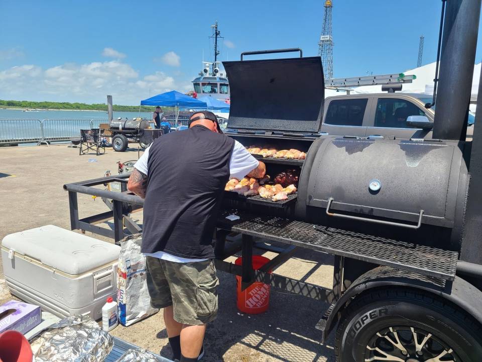 A chef stands over a large grill during Yaga's Wild Game & BBQ Cook-Off in Galveston, TX.
