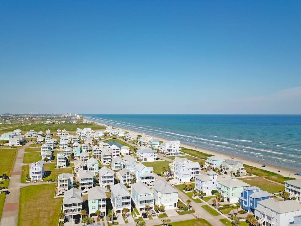An aerial view of beachside vacation rentals near the beach on a sunny day in Galveston, Texas